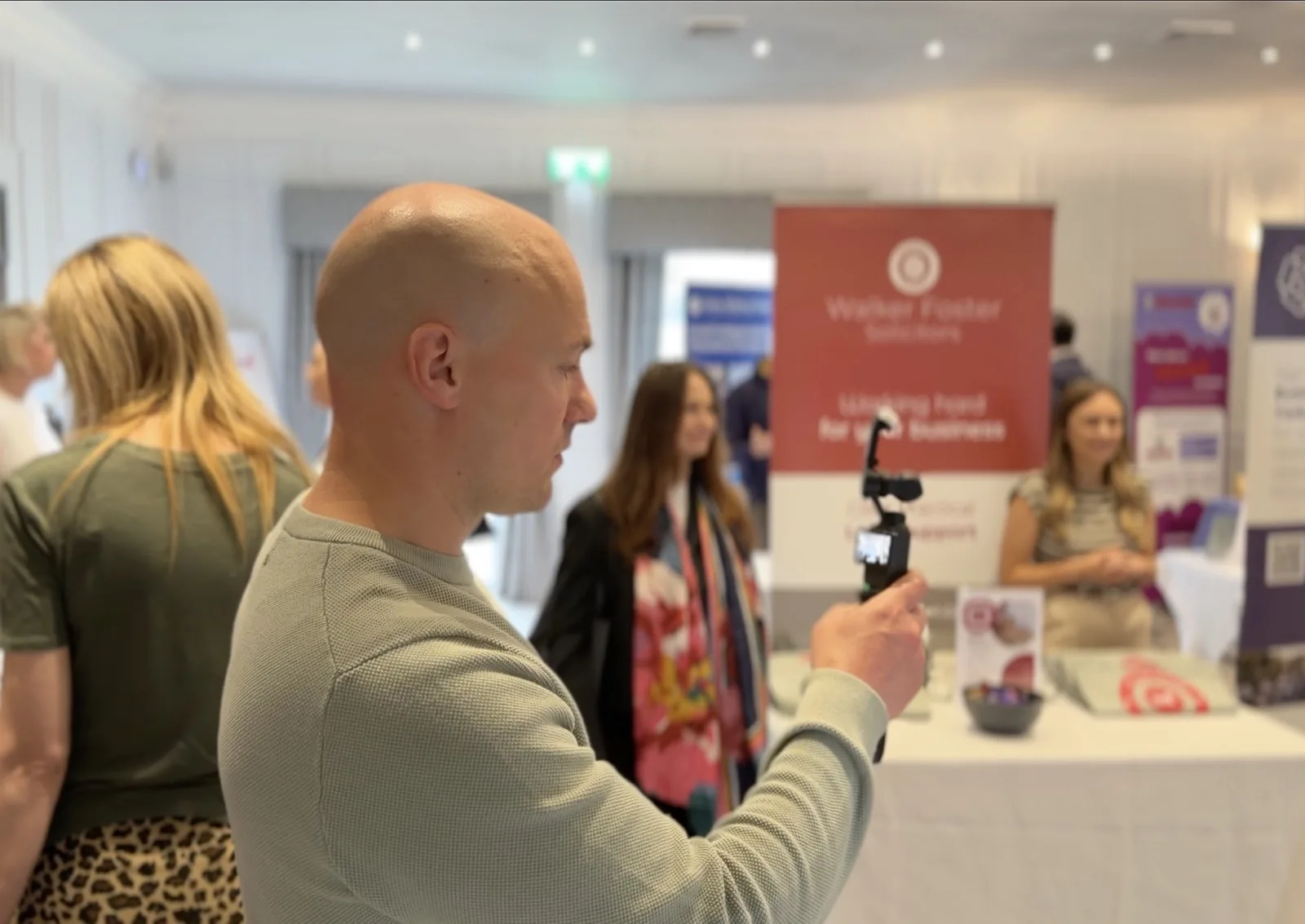 David from Halizona filming at a business expo with a phone on a gimbal